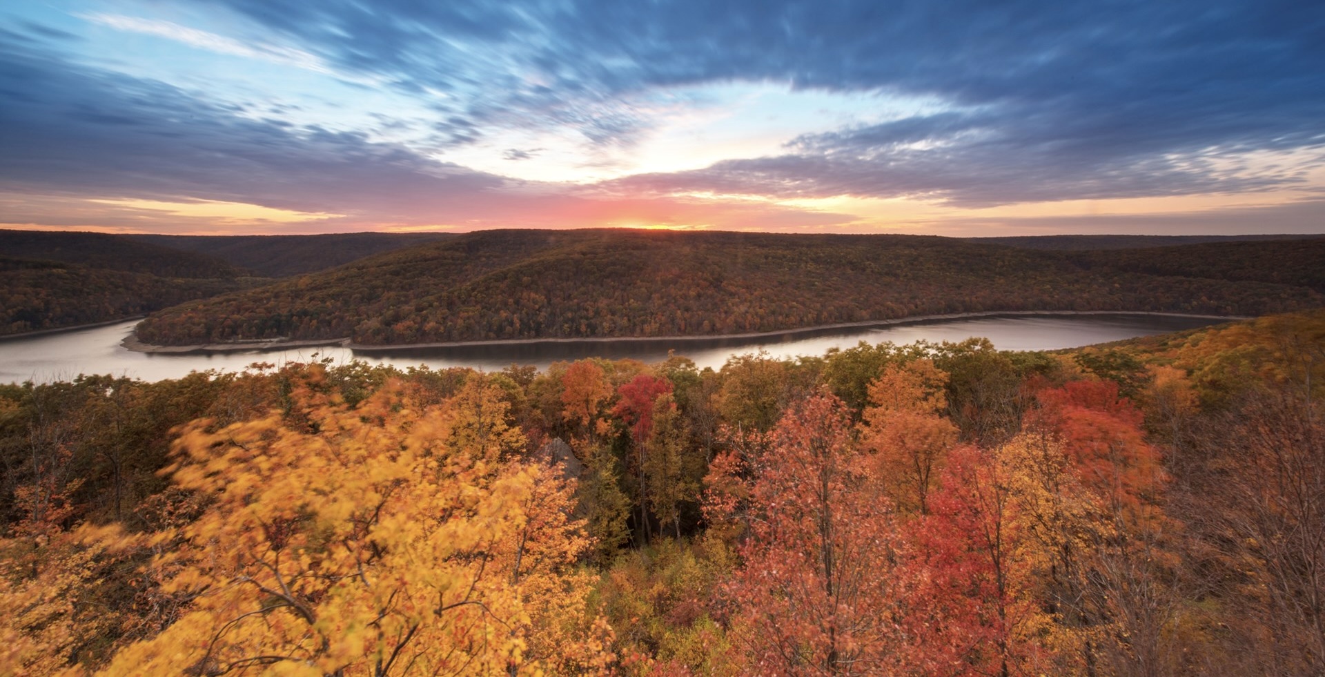 A river surrounded by hills and autumn foliage in the Allegheny National Forest