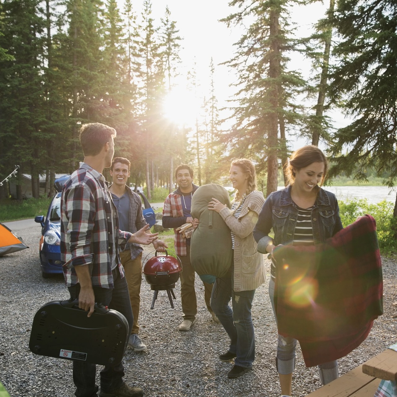 A group of friends packing a campsite in the daytime